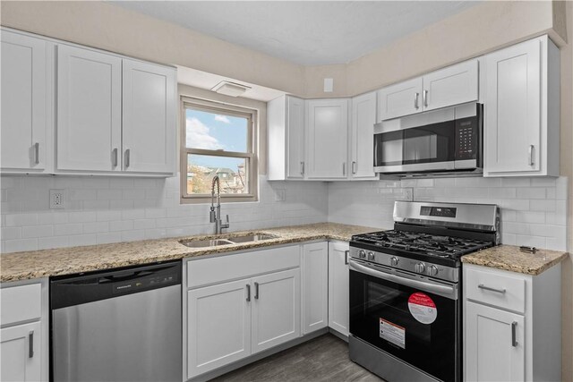 138 W Larkspur St, Munhall, PA 15120 - kitchen featuring white cabinets, a sink, tasteful backsplash, light stone countertops, and appliances with stainless steel finishes