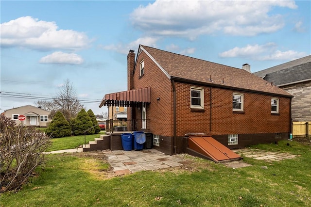138 W Larkspur St, Munhall, PA 15120 - rear view of house with a patio area, a chimney, brick siding, and a yard