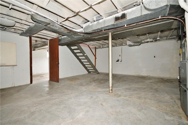 unfinished basement featuring visible vents and stairway