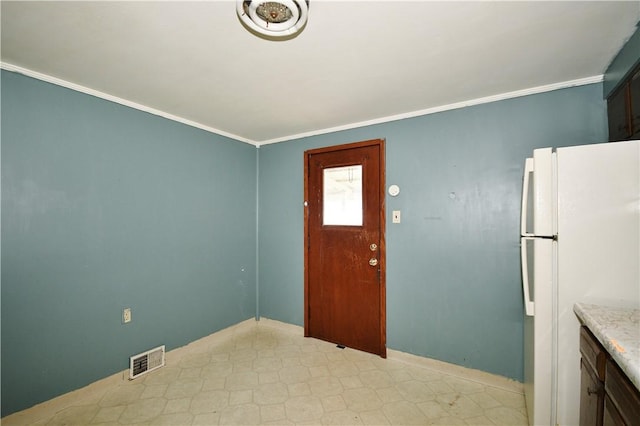 entryway featuring light floors, baseboards, crown molding, and visible vents