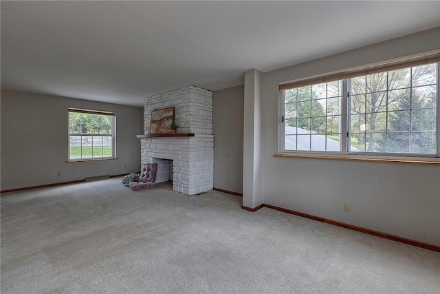 unfurnished living room featuring baseboards, a baseboard radiator, carpet flooring, and a large fireplace