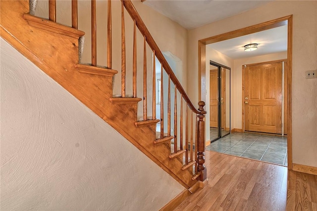 entrance foyer with baseboards, stairs, and wood finished floors