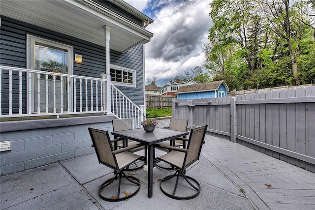 view of patio / terrace with outdoor dining area, a fenced backyard, and stairway