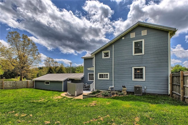 back of property featuring a fenced backyard, central air condition unit, and a lawn
