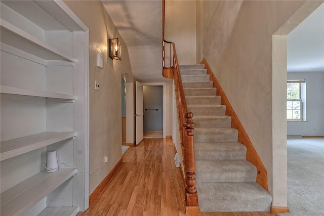 stairway featuring baseboards and wood finished floors