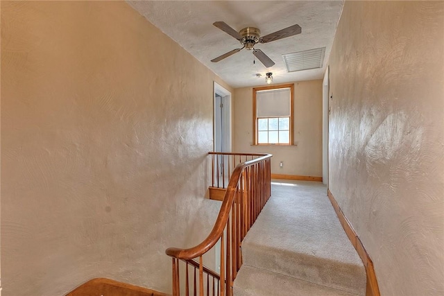 stairs with carpet flooring, baseboards, visible vents, and ceiling fan