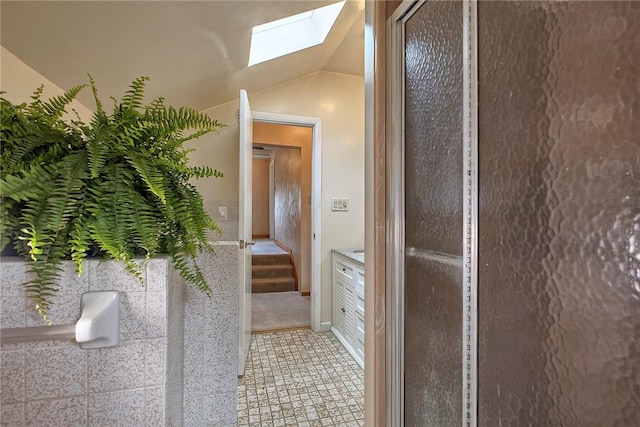 interior space with vaulted ceiling with skylight