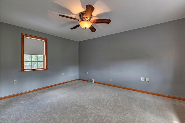 empty room with ceiling fan, visible vents, baseboards, and carpet