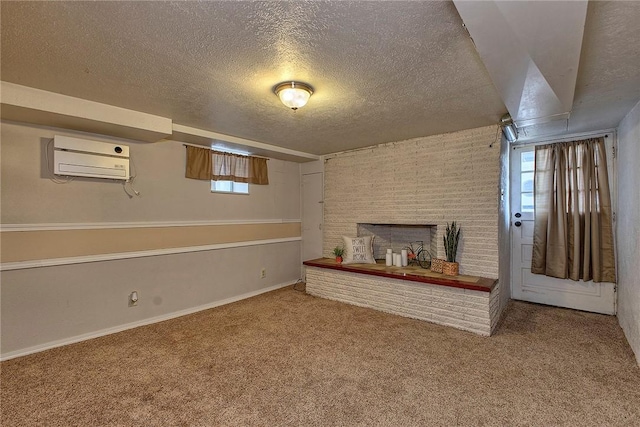 below grade area featuring a textured ceiling, a wall mounted AC, a brick fireplace, baseboards, and carpet flooring