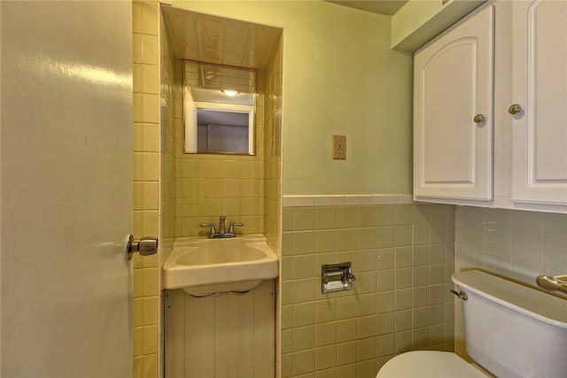 bathroom featuring vanity, toilet, and tile walls