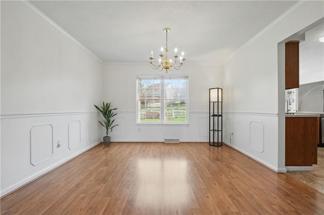 827 Brookfield Dr, Seven Fields Boro, PA 16046 - unfurnished dining area with a chandelier, light wood finished floors, ornamental molding, and wainscoting