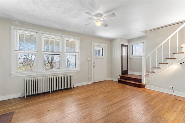 2006 Locust St, Swissvale, PA 15218 - entrance foyer with radiator heating unit, ceiling fan, light wood-style floors, stairs, and baseboards
