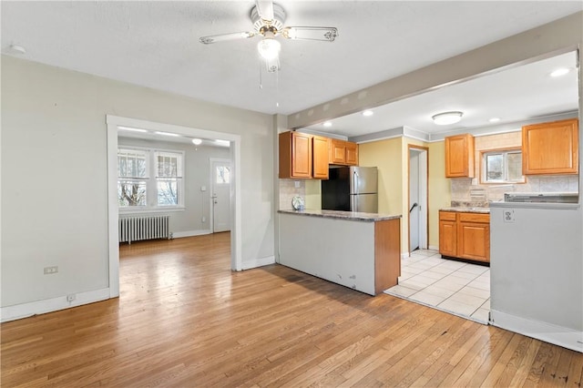 2006 Locust St, Swissvale, PA 15218 - kitchen with radiator heating unit, freestanding refrigerator, light wood finished floors, backsplash, and a ceiling fan