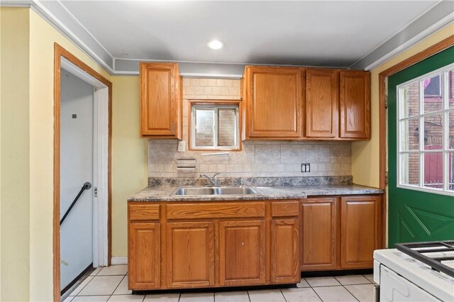 2006 Locust St, Swissvale, PA 15218 - kitchen with a sink, light tile patterned floors, backsplash, and brown cabinetry