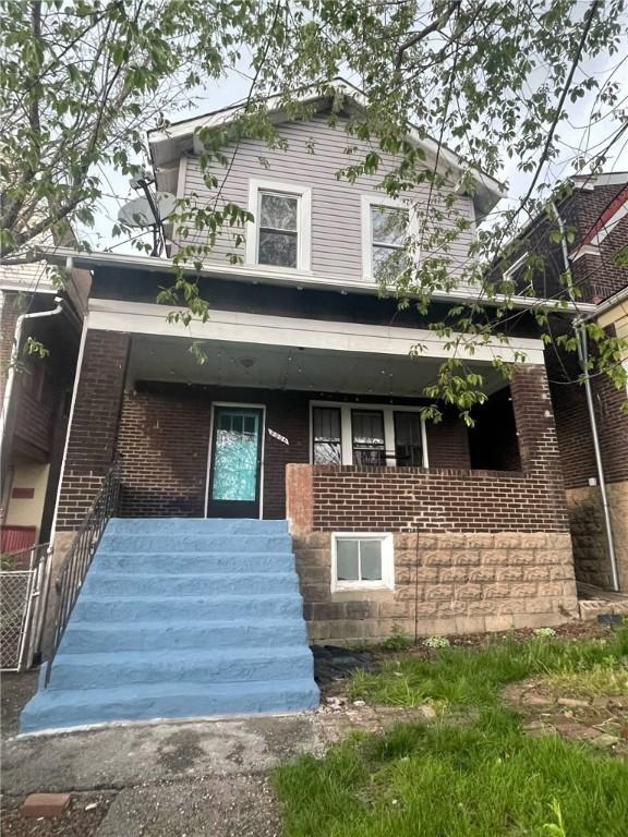 2006 Locust St, Swissvale, PA 15218 - view of front of home featuring brick siding, a porch, and stairway