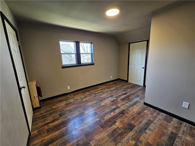 unfurnished bedroom with dark wood finished floors and baseboards