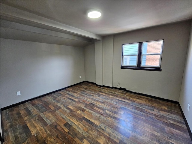 unfurnished room featuring dark wood-style floors and baseboards