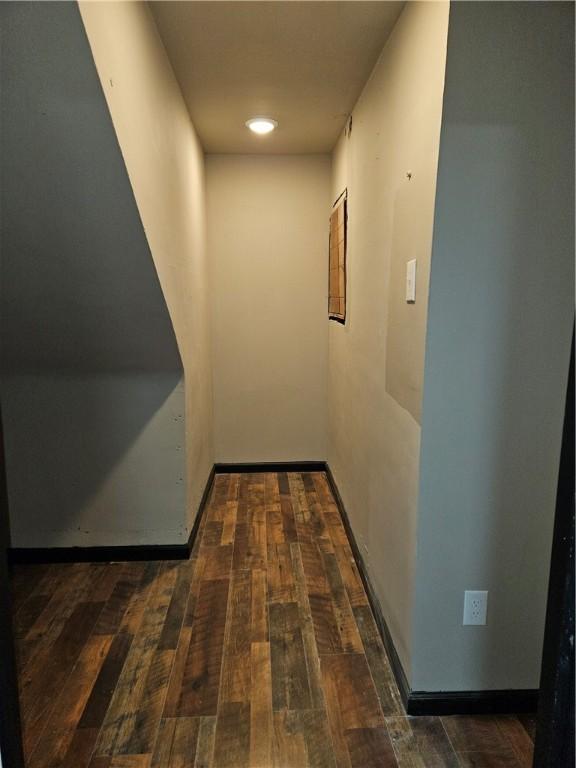 hall with wood-type flooring and baseboards