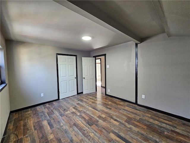 unfurnished room with dark wood-style flooring and baseboards