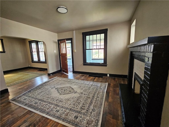 entrance foyer featuring baseboards, wood finished floors, and a fireplace