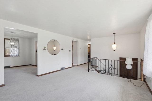 unfurnished room with visible vents, baseboards, and carpet flooring