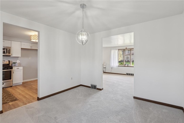 unfurnished room featuring visible vents, baseboards, and light colored carpet