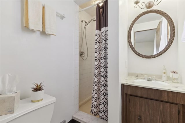 full bath with toilet, vanity, and a stall shower