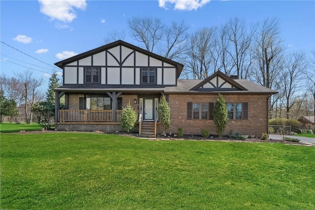 english style home with a front lawn, brick siding, and a porch