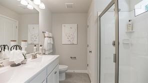 676 Olivia St, Collier Twp, PA 15205 - bathroom featuring a shower stall, toilet, a sink, and double vanity