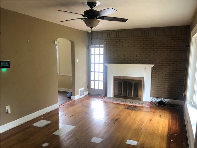 159 Oakville Rd, Chippewa Twp, PA 15010 - unfurnished living room featuring hardwood / wood-style floors, arched walkways, baseboards, a glass covered fireplace, and ceiling fan