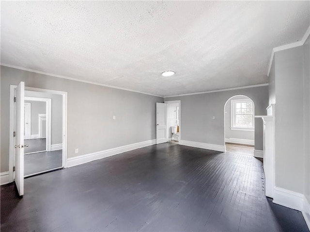 unfurnished living room with arched walkways, a textured ceiling, crown molding, and dark wood-type flooring