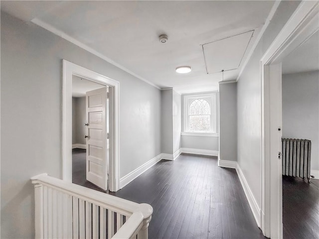 hall featuring attic access, dark wood finished floors, radiator heating unit, and crown molding
