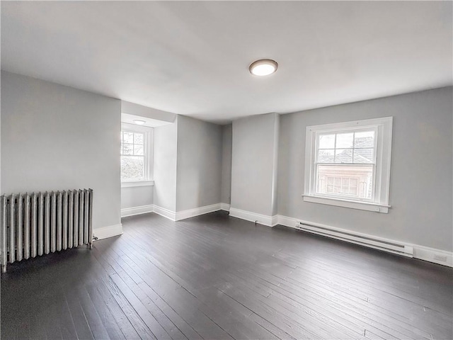 empty room featuring radiator, dark wood finished floors, plenty of natural light, and a baseboard radiator