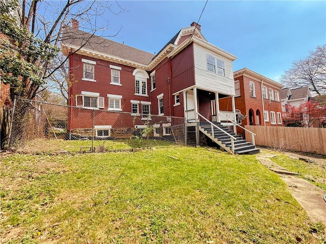rear view of property featuring fence private yard, a lawn, and a chimney