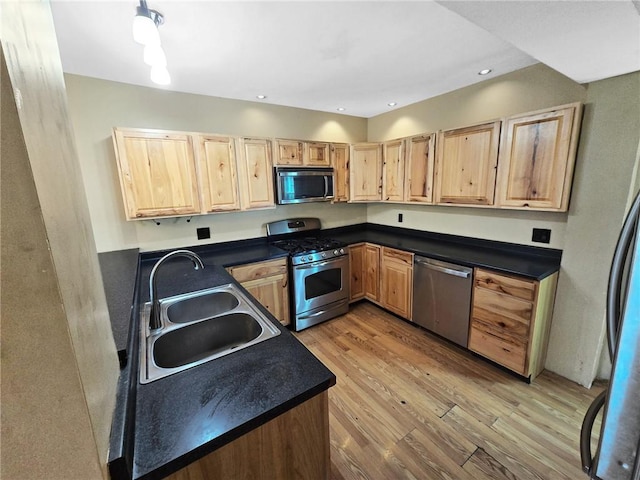 100 Shenango Blvd, Farrell, PA 16121 - kitchen with dark countertops, light brown cabinets, a sink, light wood-style floors, and appliances with stainless steel finishes