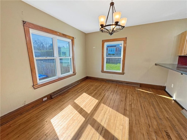 100 Shenango Blvd, Farrell, PA 16121 - unfurnished dining area with baseboards, an inviting chandelier, baseboard heating, hardwood / wood-style floors, and a baseboard radiator