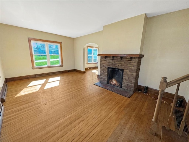 100 Shenango Blvd, Farrell, PA 16121 - unfurnished living room featuring plenty of natural light, baseboards, a fireplace, and wood-type flooring