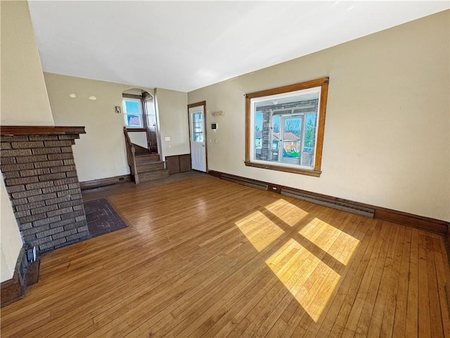 100 Shenango Blvd, Farrell, PA 16121 - unfurnished living room with wood-type flooring, arched walkways, stairs, and baseboards