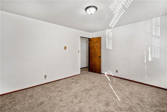 carpeted spare room featuring baseboards