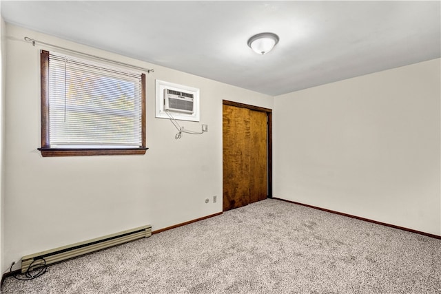 spare room featuring a baseboard heating unit, baseboards, an AC wall unit, and carpet floors