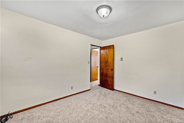 carpeted spare room with baseboards