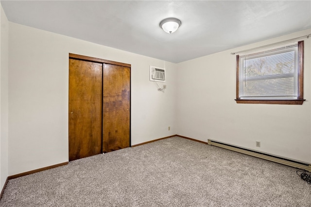 unfurnished bedroom featuring a baseboard radiator, a closet, carpet flooring, and a wall unit AC
