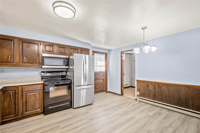 kitchen featuring a baseboard heating unit, stainless steel appliances, an inviting chandelier, light wood-style floors, and light countertops
