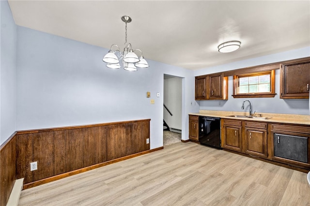 kitchen with light wood finished floors, light countertops, dishwasher, a sink, and a notable chandelier