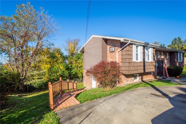 view of home's exterior with fence, brick siding, and a yard