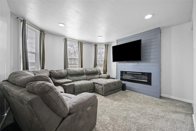 carpeted living room featuring baseboards, a large fireplace, and recessed lighting