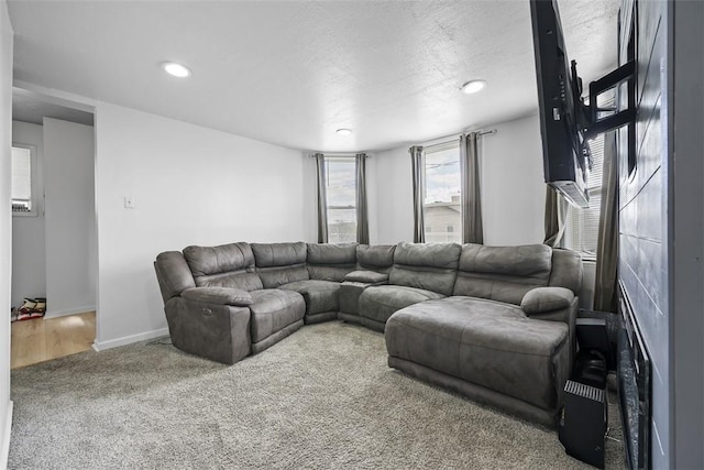 carpeted living area featuring baseboards, recessed lighting, and a textured ceiling