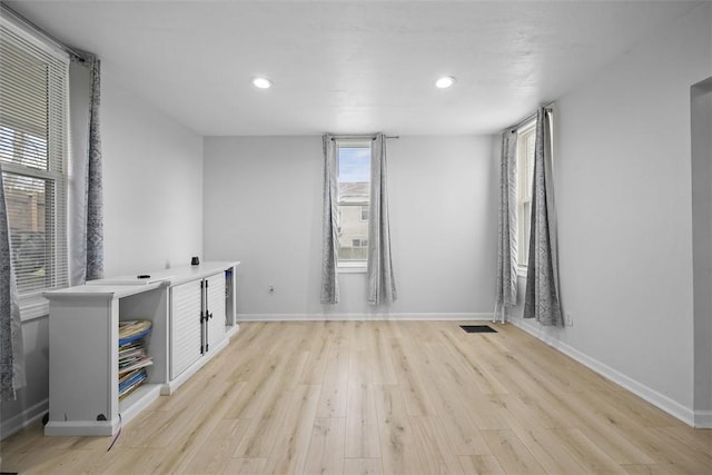 empty room with visible vents, light wood-style flooring, baseboards, and recessed lighting