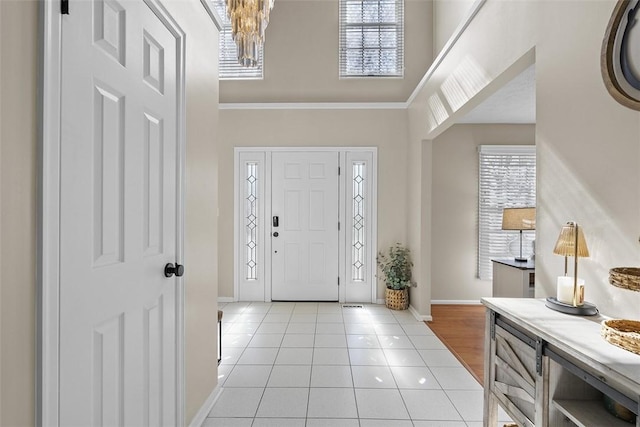 158 Edgemeade Dr, Monroeville, PA 15146 - entryway featuring crown molding, light tile patterned floors, a towering ceiling, baseboards, and a notable chandelier