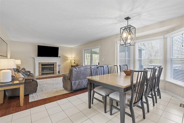 158 Edgemeade Dr, Monroeville, PA 15146 - dining room with visible vents, a brick fireplace, baseboards, and light tile patterned floors